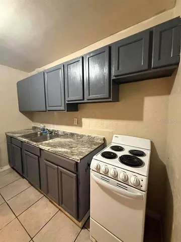 a kitchen with granite countertop cabinets and stove top oven