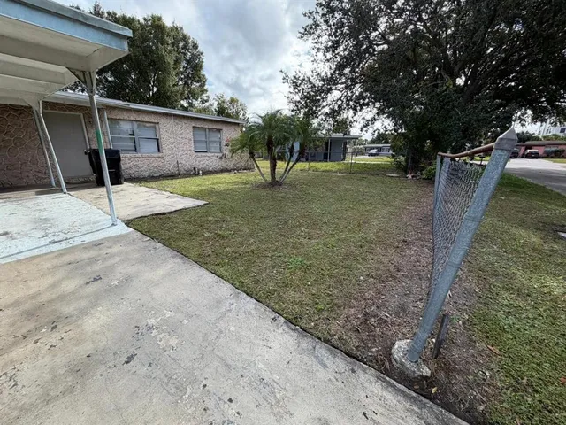 a view of a house with backyard and trees