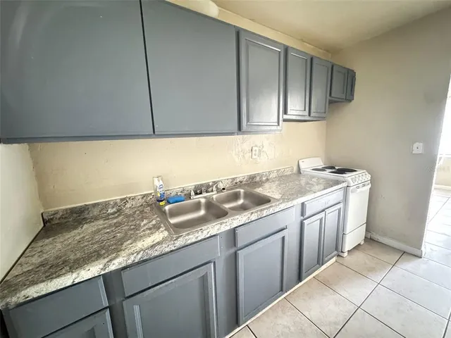 a kitchen with granite countertop cabinets sink and stove