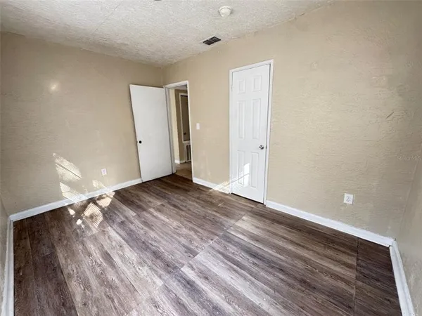 a view of empty room with wooden floor