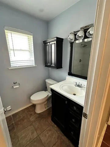 a bathroom with a toilet sink and mirror