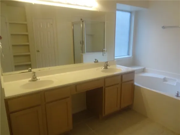 a bathroom with a tub sink and mirror