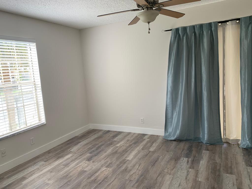 6315 La Costa Drive, Unit E Boca Raton, FL 33433 - Photo 11 of 22 wooden floor in an empty room with a window