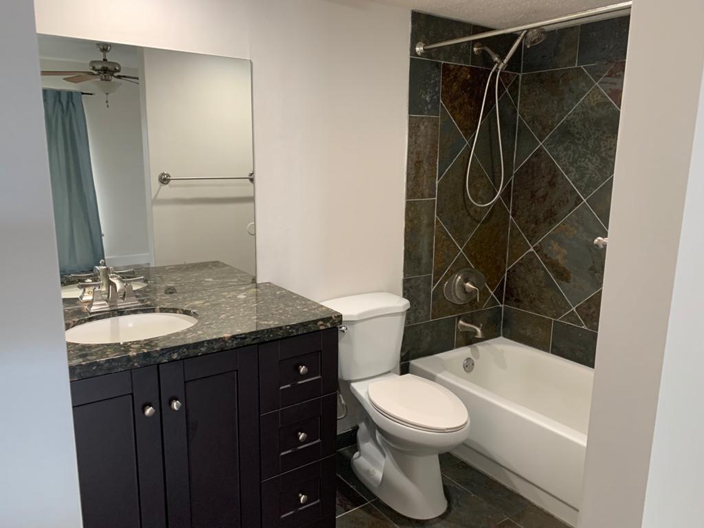 6315 La Costa Drive, Unit E Boca Raton, FL 33433 - Photo 12 of 22 a bathroom with a granite countertop sink toilet and shower