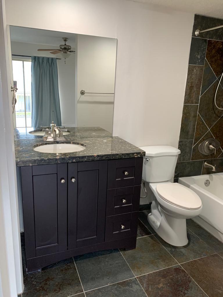 6315 La Costa Drive, Unit E Boca Raton, FL 33433 - Photo 14 of 22 a bathroom with a granite countertop toilet sink and mirror