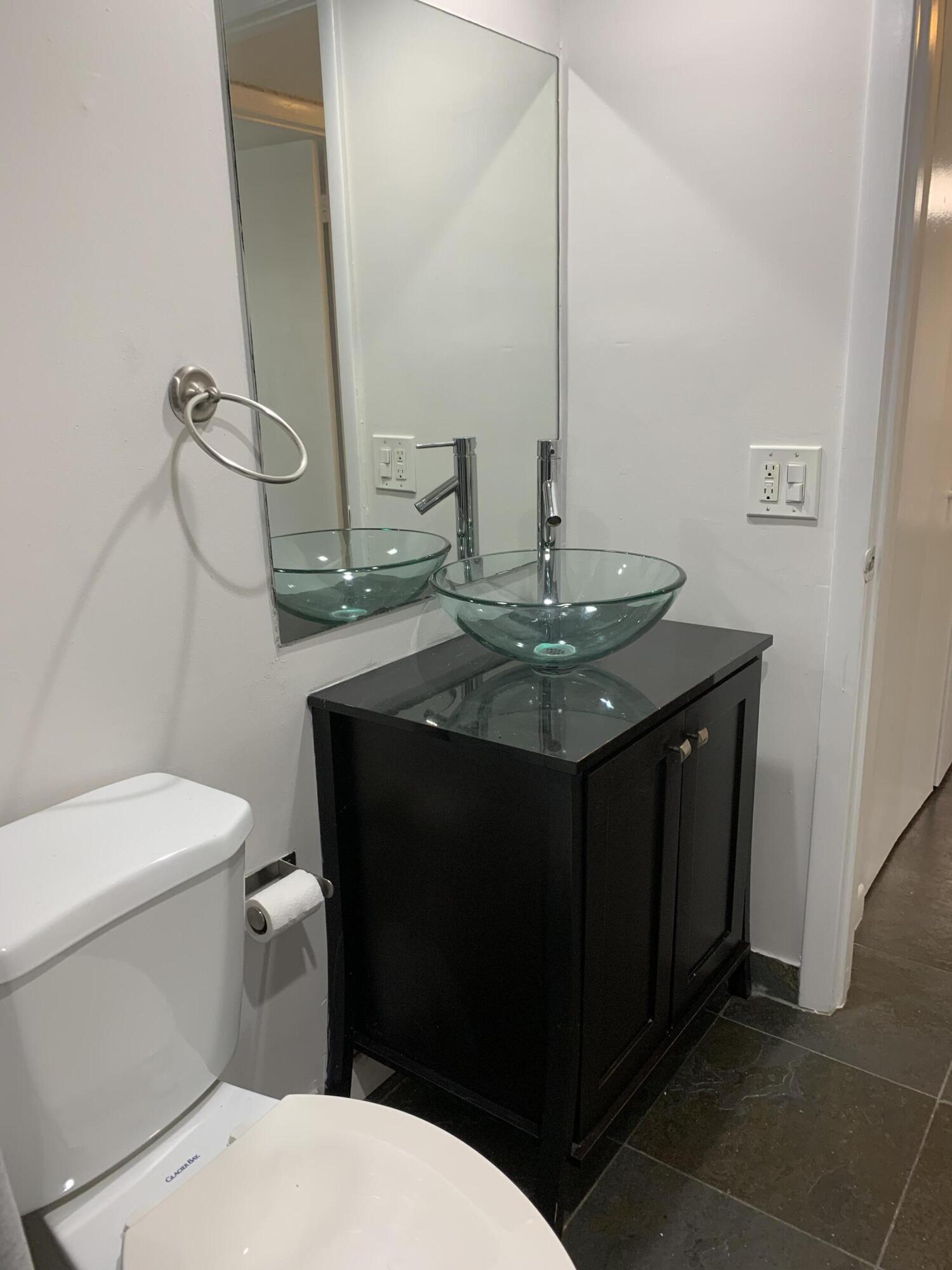 6315 La Costa Drive, Unit E Boca Raton, FL 33433 - Photo 17 of 22 a bathroom with a toilet sink and mirror