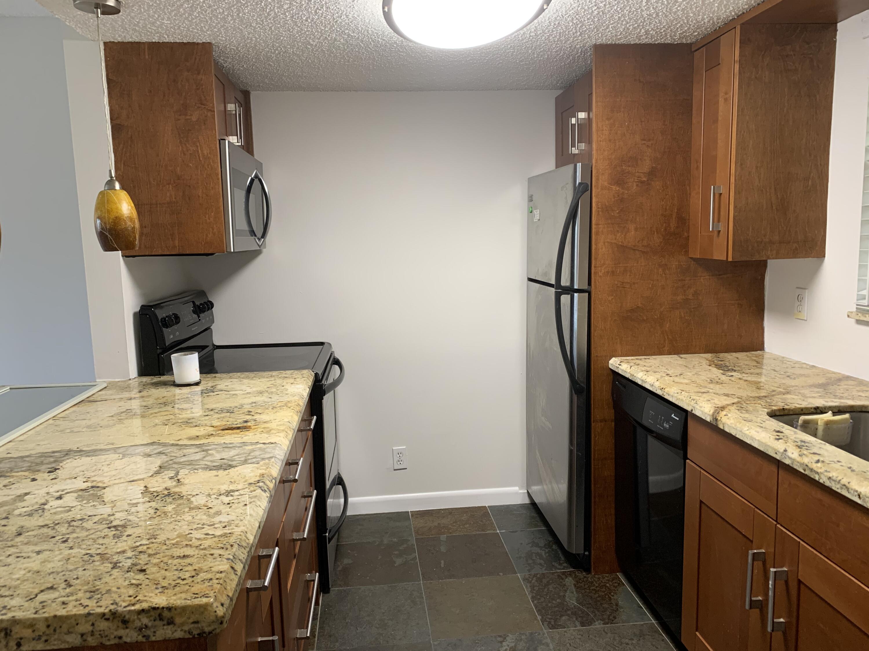 6315 La Costa Drive, Unit E Boca Raton, FL 33433 - Photo 2 of 22 a kitchen with a sink and a refrigerator