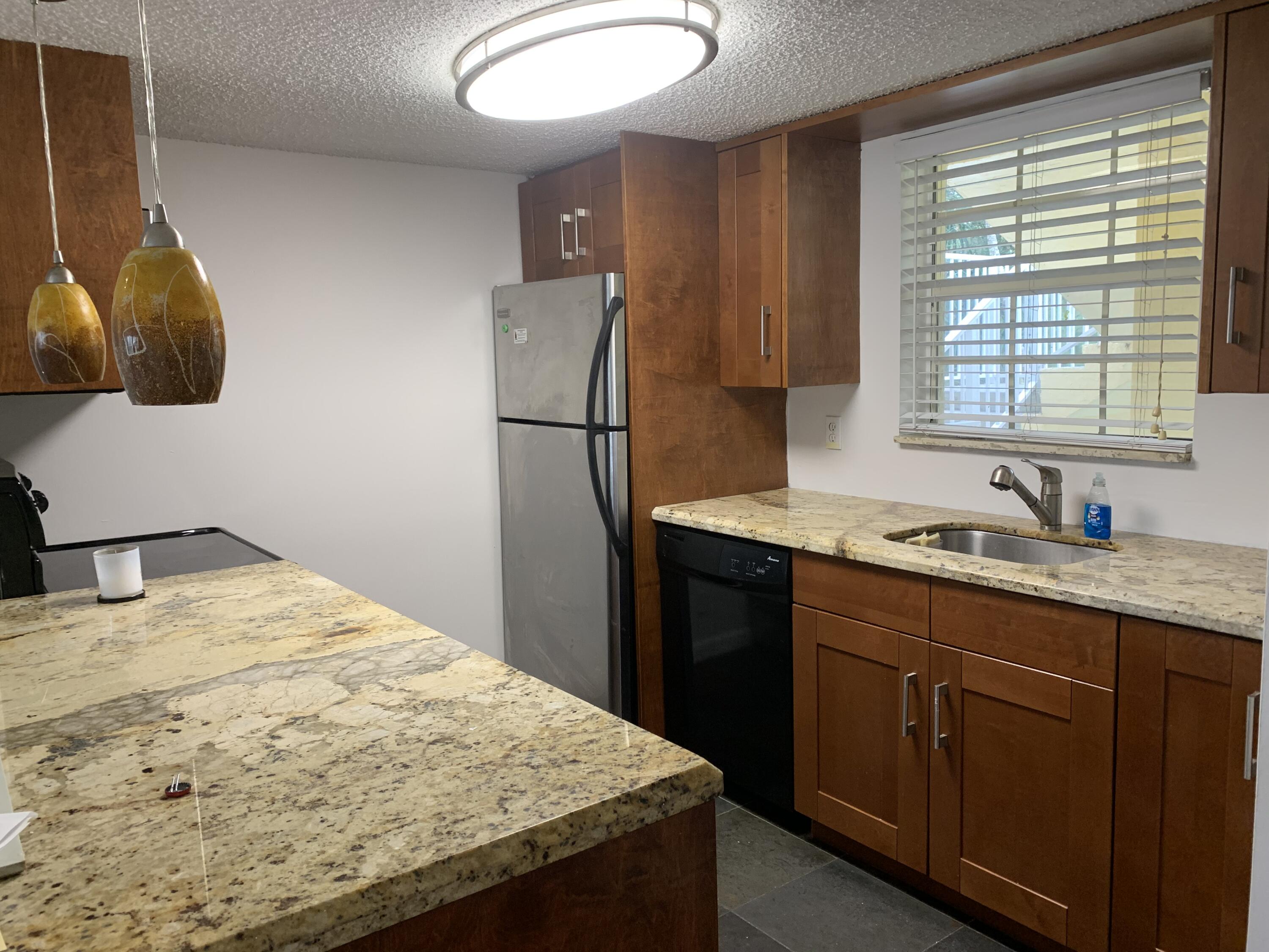 6315 La Costa Drive, Unit E Boca Raton, FL 33433 - Photo 3 of 22 a kitchen with a sink a refrigerator and cabinets