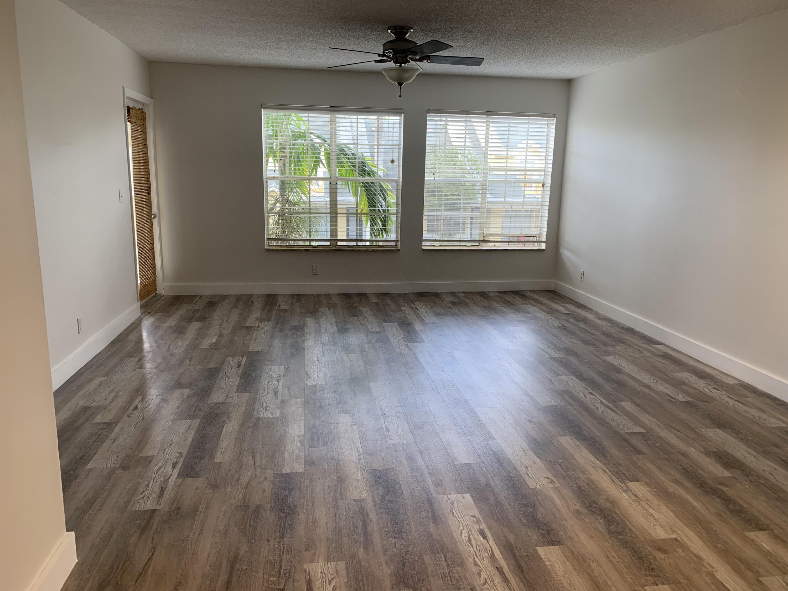 6315 La Costa Drive, Unit E Boca Raton, FL 33433 - Photo 7 of 22 an empty room with wooden floor ceiling fan and windows