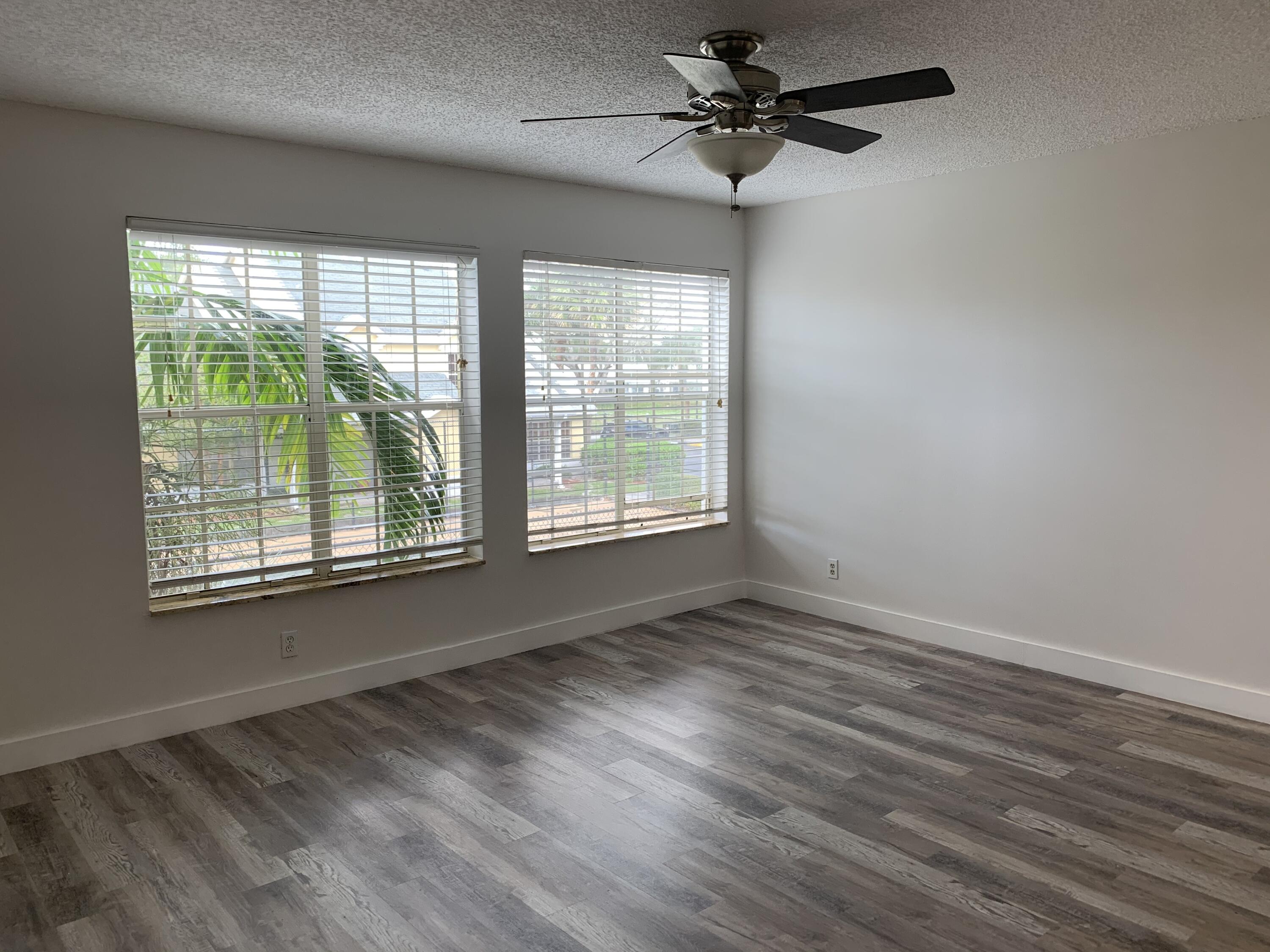 6315 La Costa Drive, Unit E Boca Raton, FL 33433 - Photo 8 of 22 a view of an empty room with a window and wooden floor