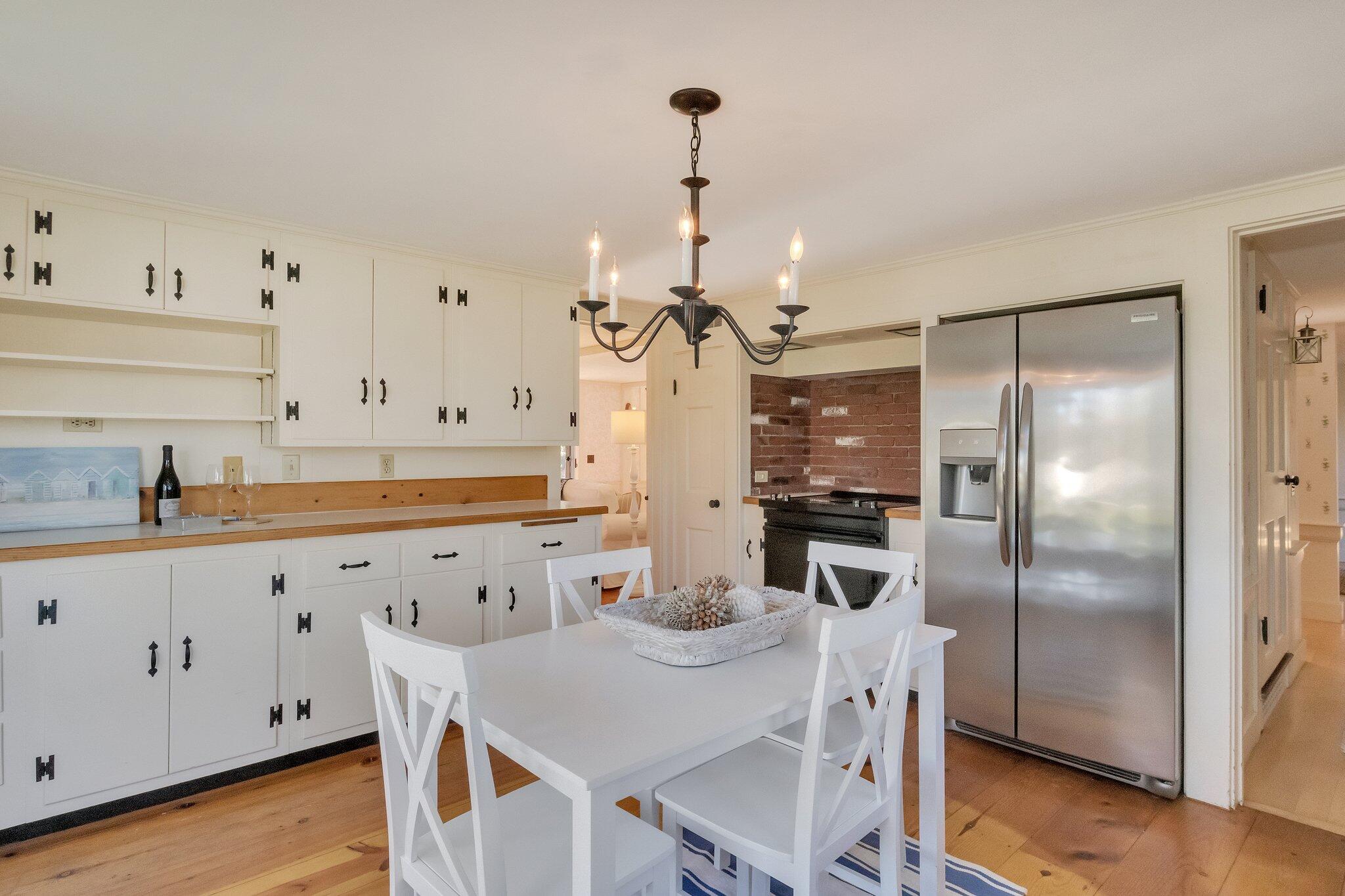 400 Lower County Road Harwich Port, MA 02646 - Photo 16 of 49 a kitchen with granite countertop a refrigerator a stove a sink and white cabinets with wooden floor