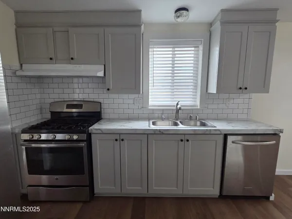 a kitchen with cabinets appliances and a sink