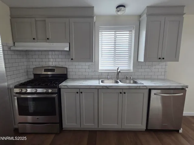 a kitchen with cabinets appliances and a sink
