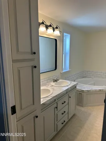 a bathroom with a granite countertop sink and mirror