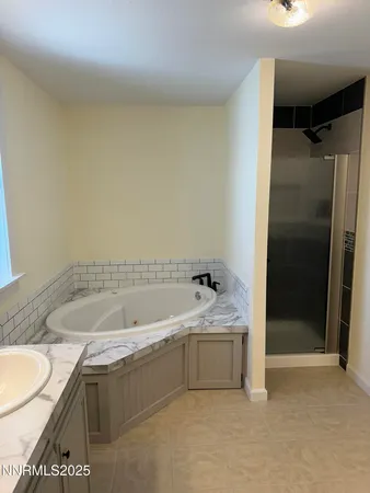 a bathroom with a granite countertop sink and a bathtub