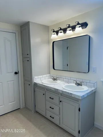 a en suite bathroom with a double vanity sink and mirror