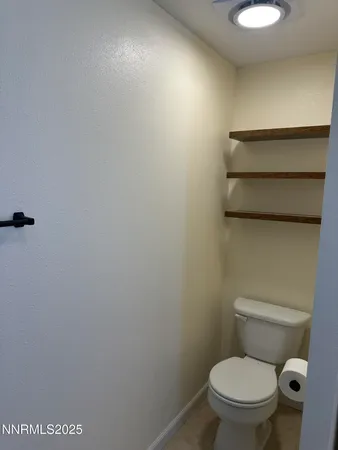 a white toilet sitting next to a white sink and vanity