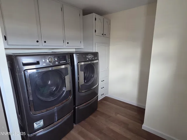 a utility room with wooden floor washer and dryer