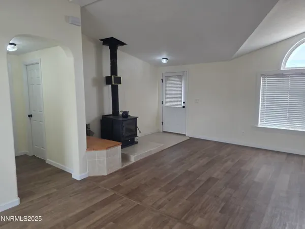 a view of a livingroom with wooden floor and staircase
