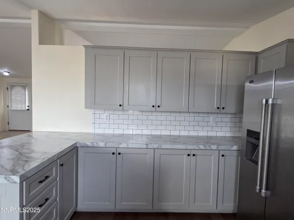 a kitchen with granite countertop a wooden cabinets and refrigerator