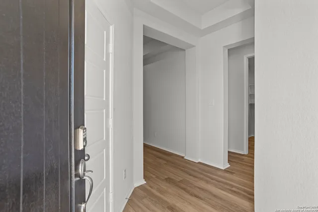 a view of a hallway with wooden floor