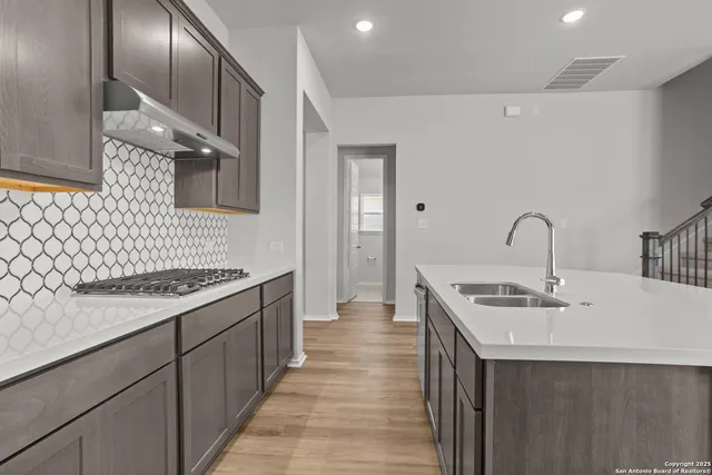 a kitchen with a sink and a stove top oven