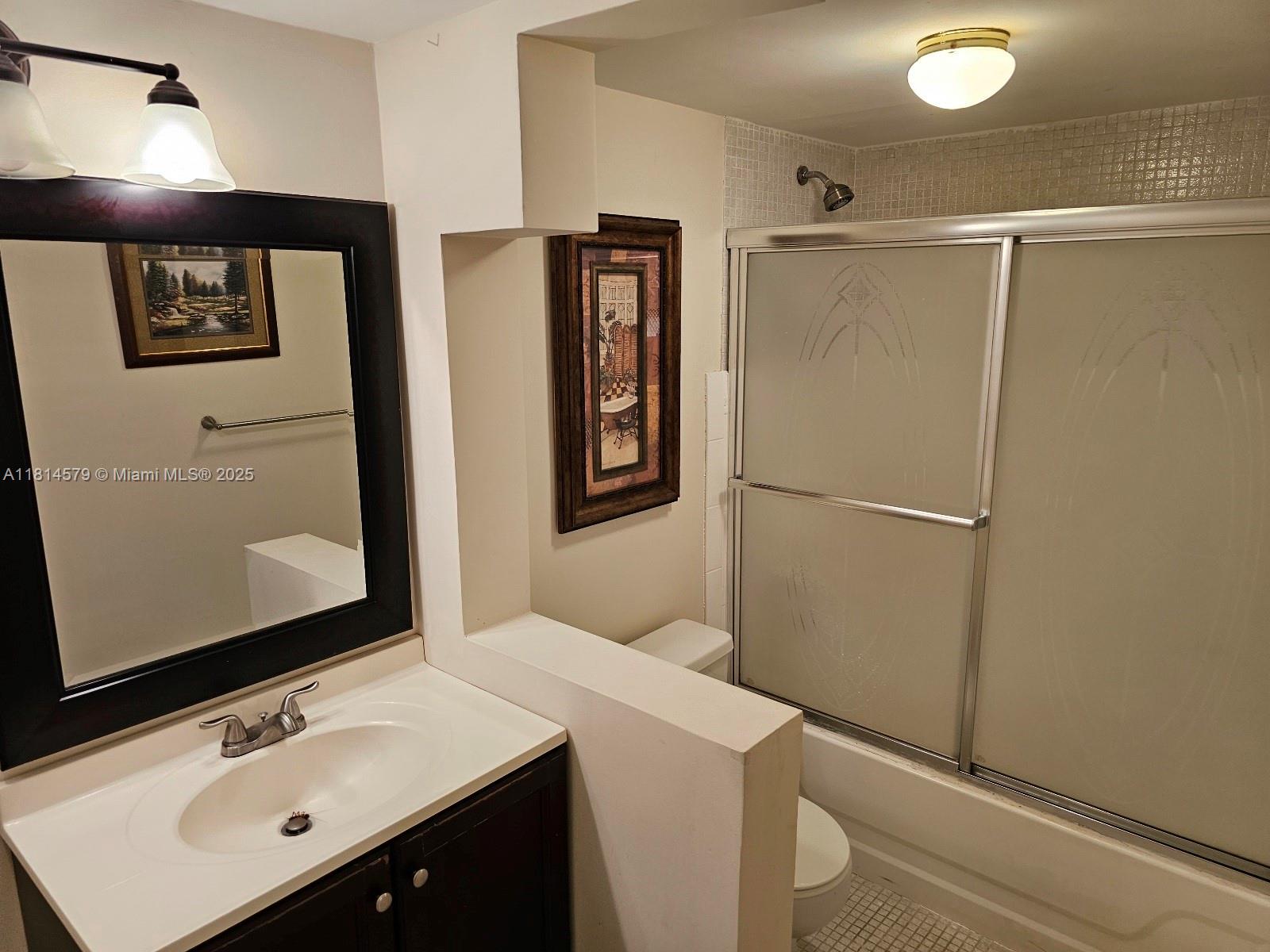 8380 Sands Point Boulevard, Unit J110 Tamarac, FL 33321 - Photo 11 of 34 a bathroom with a sink a mirror and a shower