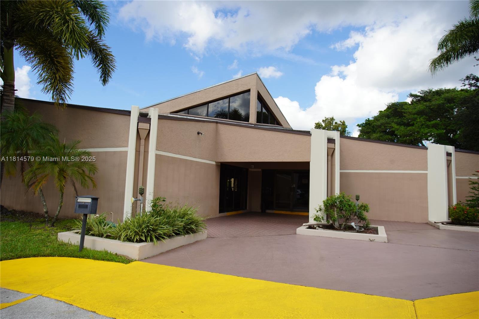 8380 Sands Point Boulevard, Unit J110 Tamarac, FL 33321 - Photo 21 of 34 a front view of a house with a yard and garage