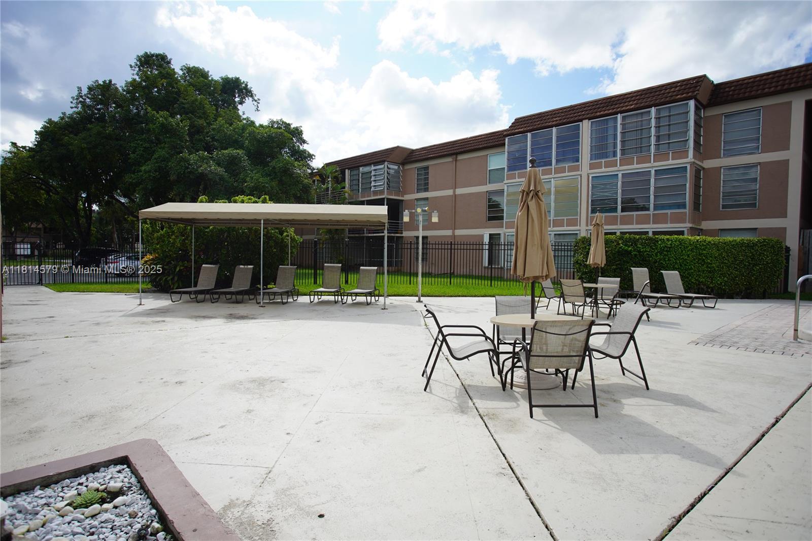 8380 Sands Point Boulevard, Unit J110 Tamarac, FL 33321 - Photo 28 of 34 a view of a patio with a table and chairs under an umbrella