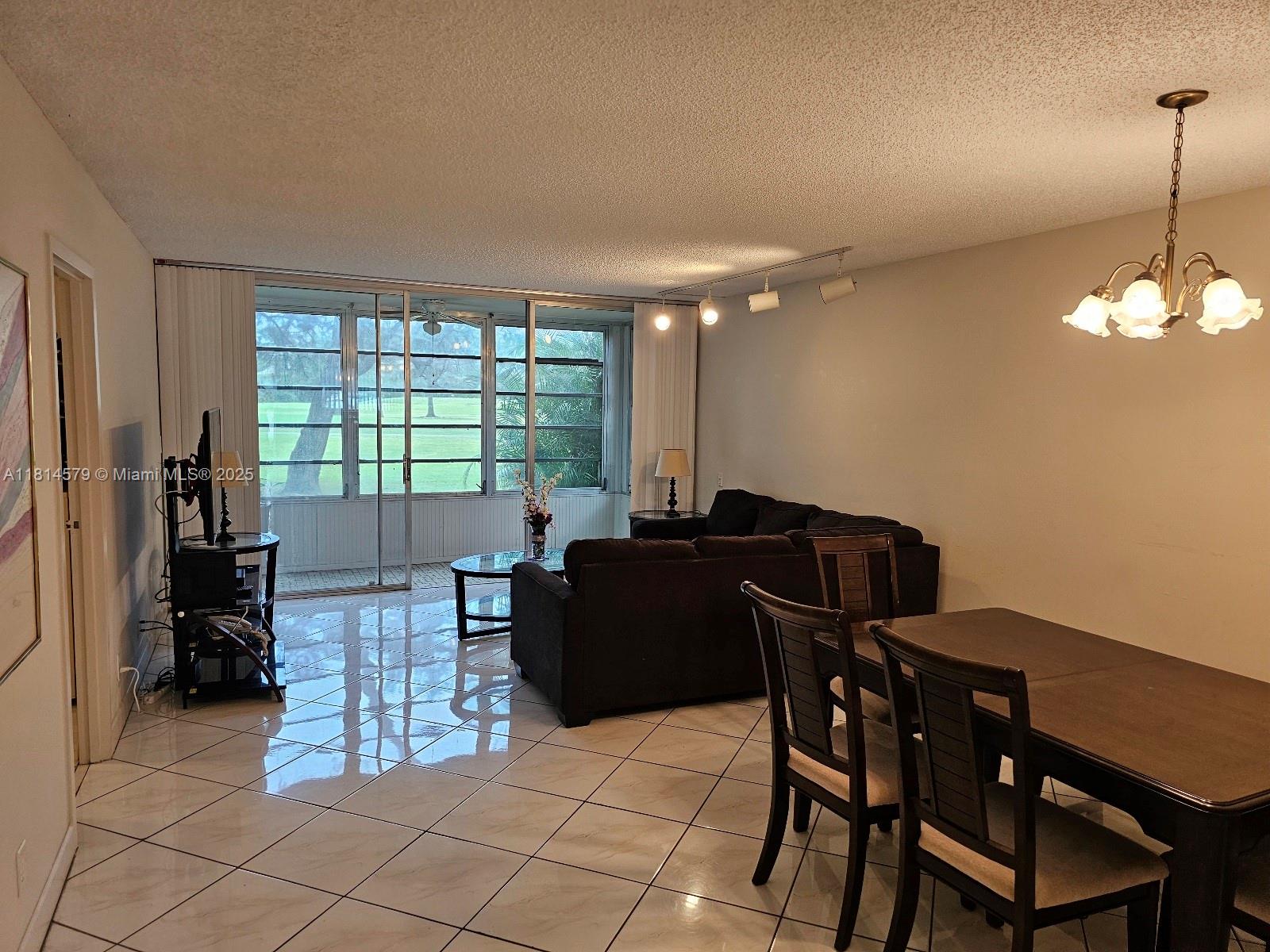 8380 Sands Point Boulevard, Unit J110 Tamarac, FL 33321 - Photo 3 of 34 a living room with furniture and a large window