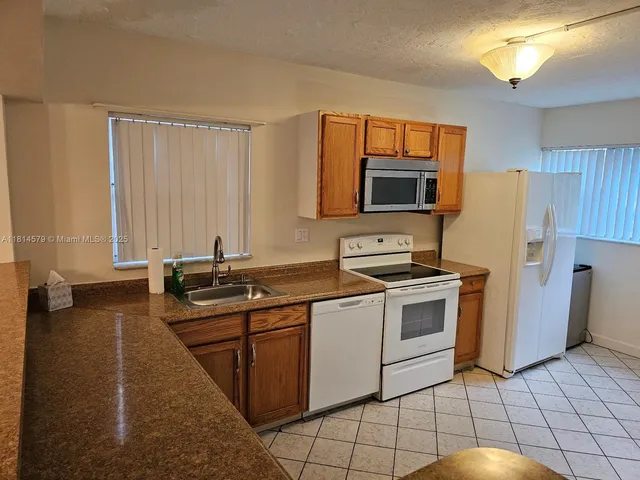 a kitchen with stainless steel appliances a stove sink and microwave