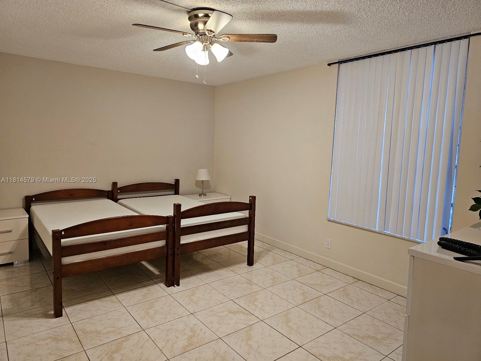 8380 Sands Point Boulevard, Unit J110 Tamarac, FL 33321 - Photo 8 of 34 a bedroom with furniture and a chandelier