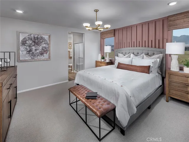 a bed room with a bed mirror and a chandelier