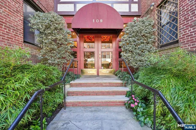 a front view of a house with a yard and potted plants