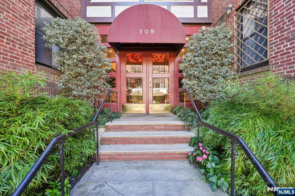 109 Grand Avenue, Unit 4A Englewood, NJ 07631 - Photo 1 of 39 a front view of a house with a yard and potted plants