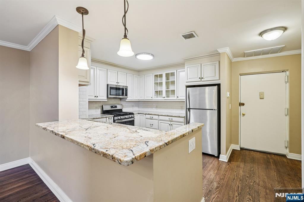 109 Grand Avenue, Unit 4A Englewood, NJ 07631 - Photo 14 of 39 a kitchen with stainless steel appliances granite countertop a sink a stove a refrigerator cabinets and wooden floor