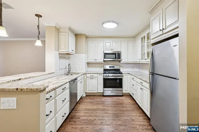 a kitchen with white cabinets and stainless steel appliances