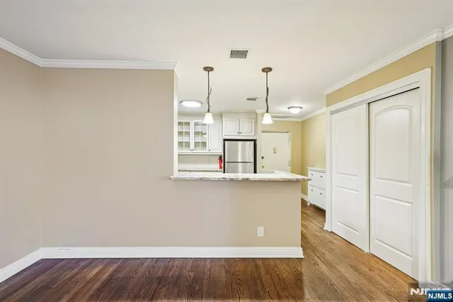 a kitchen with a refrigerator a stove a sink dishwasher a oven with white cabinets and wooden floor