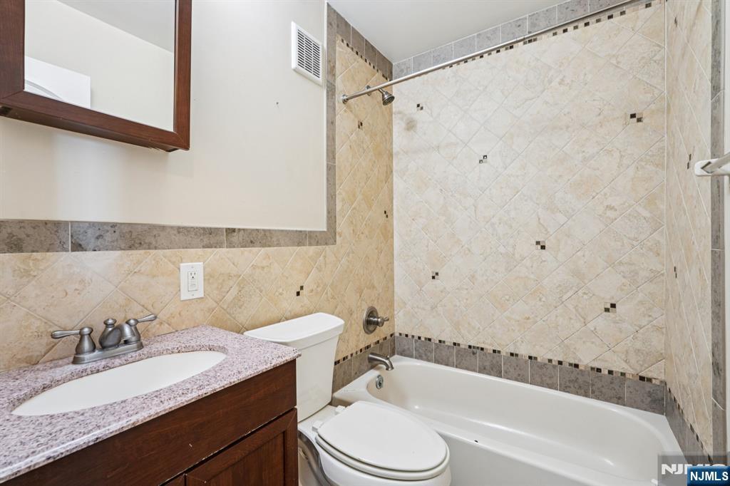 109 Grand Avenue, Unit 4A Englewood, NJ 07631 - Photo 30 of 39 a bathroom with a granite countertop sink toilet and shower