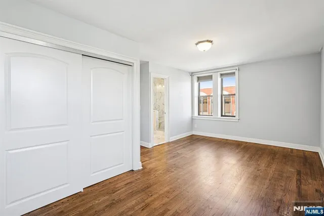a view of an empty room with wooden floor