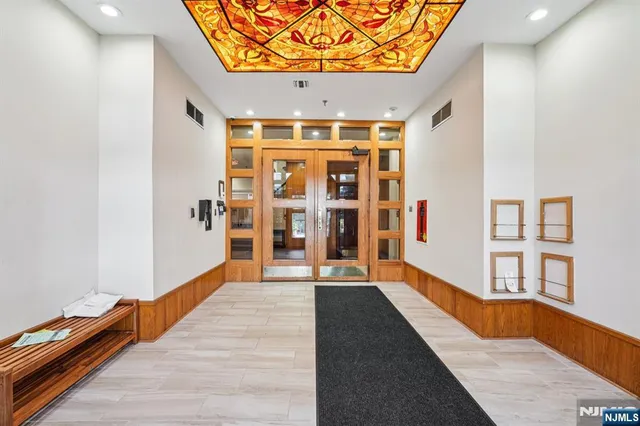 wooden floor in a hall with a large window and chandelier