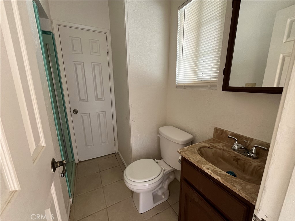 12014 Oasis Road Pinon Hills, CA 92372 - Photo 12 of 16 a bathroom with a granite countertop toilet sink and mirror