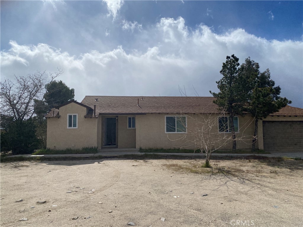 12014 Oasis Road Pinon Hills, CA 92372 - Photo 2 of 16 a front view of a house with a yard and garage