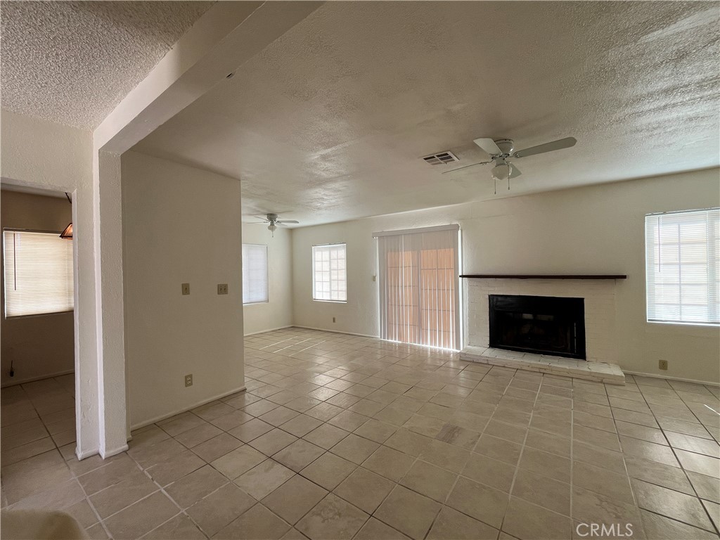 12014 Oasis Road Pinon Hills, CA 92372 - Photo 4 of 16 an empty room with windows and fireplace