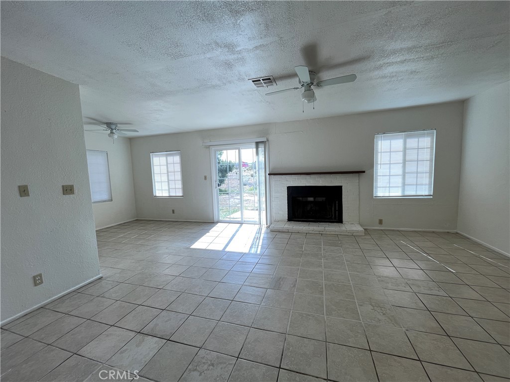 12014 Oasis Road Pinon Hills, CA 92372 - Photo 5 of 16 a view of an empty room with a fireplace and a window