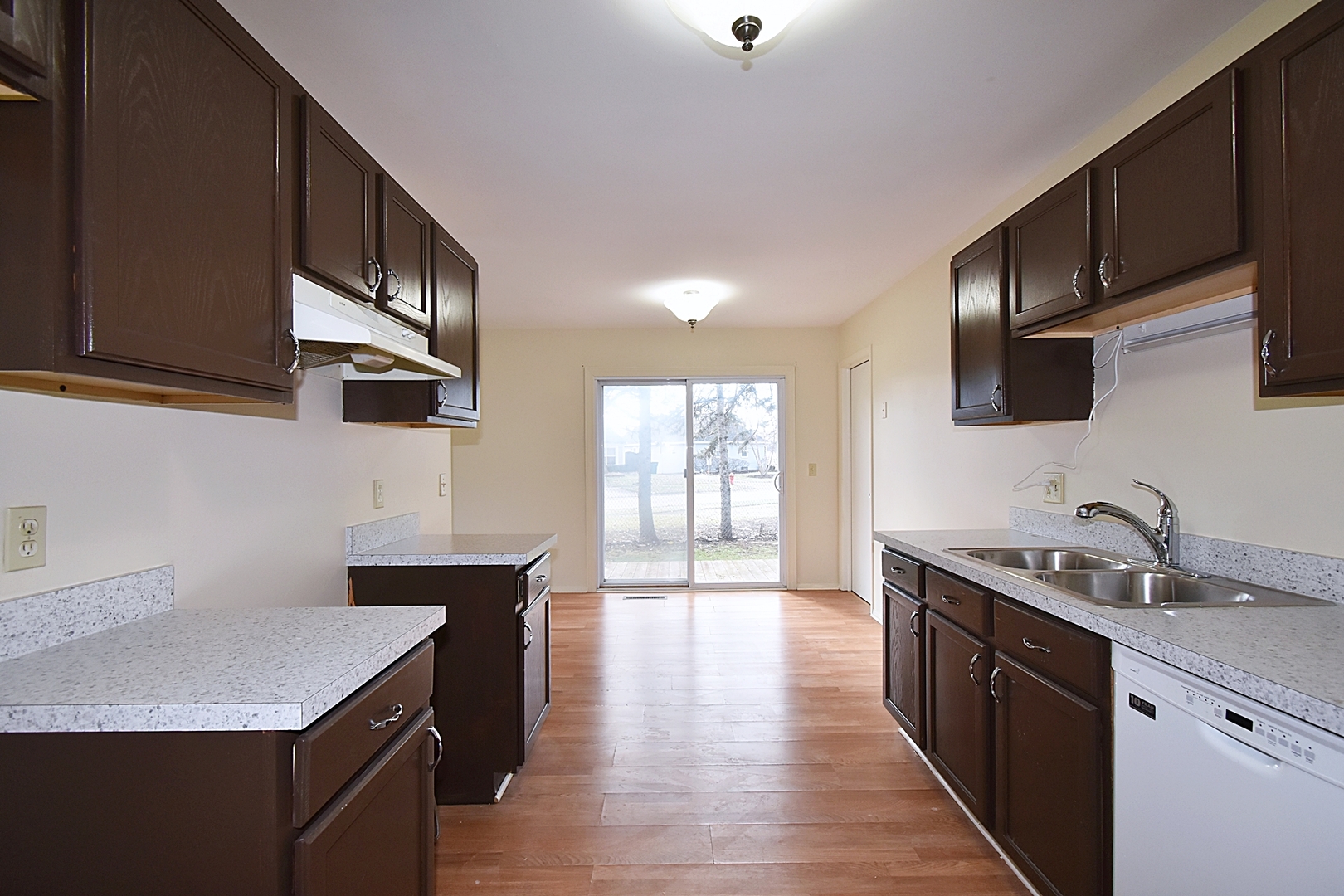 103 Tealwood Road Montgomery, IL 60538 - Photo 9 of 23 a kitchen with a sink dishwasher a stove top oven a refrigerator with wooden cabinets and floor