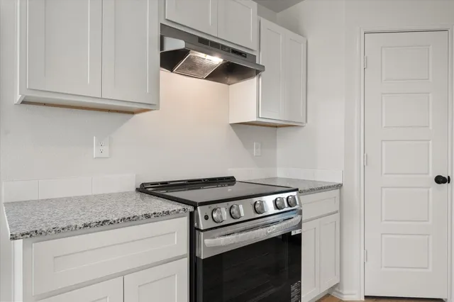 a stove top oven sitting inside of a kitchen