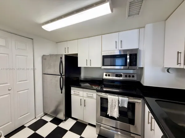 a kitchen with a stove refrigerator and microwave