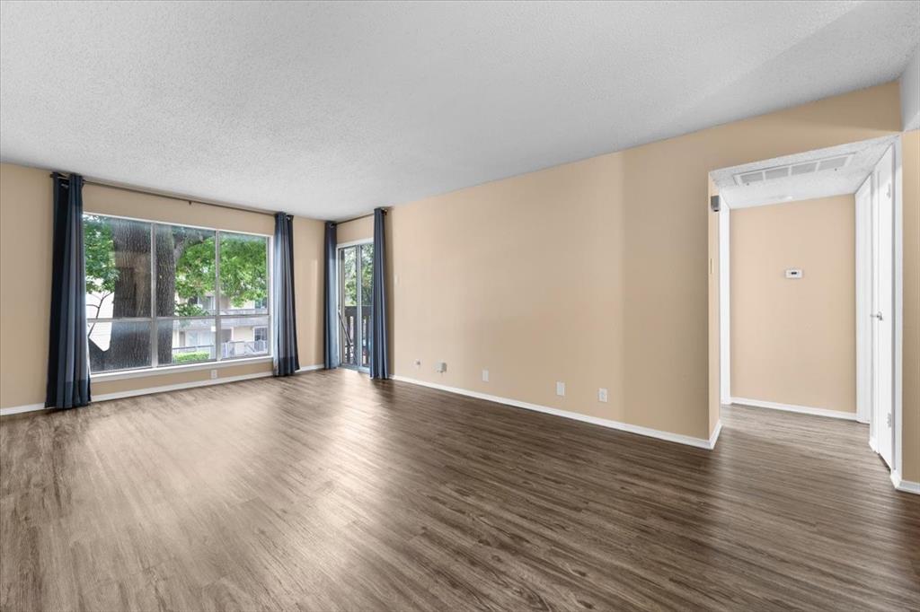 4859 Cedar Springs Road, Unit 241 Dallas, TX 75219 - Photo 3 of 38 a view of an empty room with wooden floor and a window