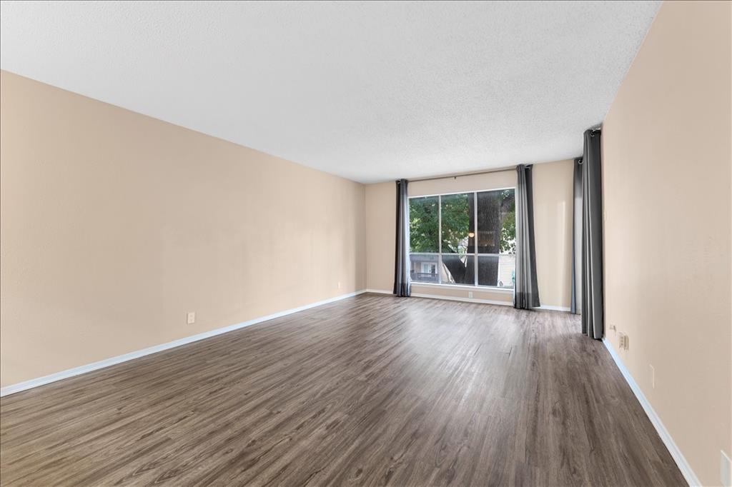4859 Cedar Springs Road, Unit 241 Dallas, TX 75219 - Photo 4 of 38 a view of an empty room with wooden floor and a window